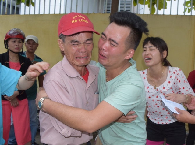 Ông nội và cha của hai cháu bé nạn nhân ôm nhau khóc khi biết con cháu mình đã mãi lìa xa. Ảnh: VnExpress