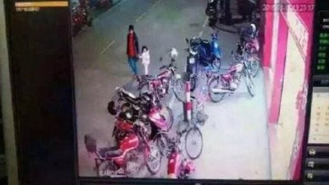 Ảnh chụp từ camera an ninh cho thấy người phụ nữ đã dẫn bé gái rời khỏi nhà. Ảnh: Huaxi Daily