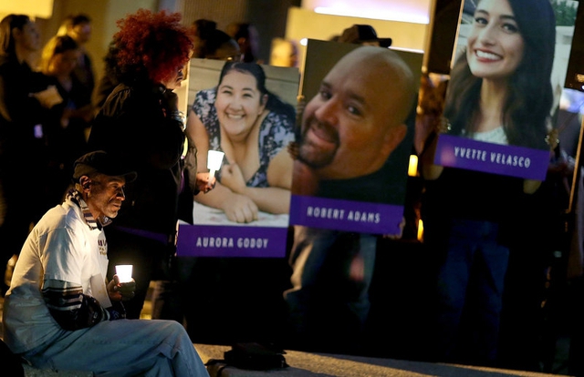 
Một người đàn ông ngồi tưởng niệm trước di ảnh của các nạn nhân trong vụ xả súng tại Sở y tế San Bernardino (Ảnh: Getty)
