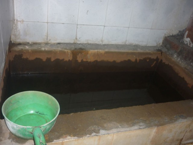 
Bể chứa nước dội lộ thiên, không có vòi và phải múc bằng gáo.
