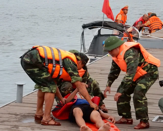 
Một nạn nhân bị hôn mê, được đưa lên cầu cảng sông Hàn sơ cứu...
