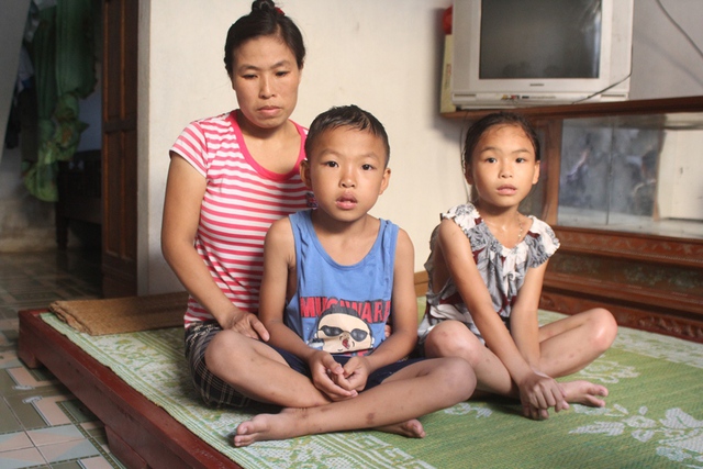 Chị Đồng Thị Bảo cùng hai con nhỏ ngồi trong căn nhà tình nghĩa được nhà nước xây tặng năm 2011. Ảnh: Đình Việt