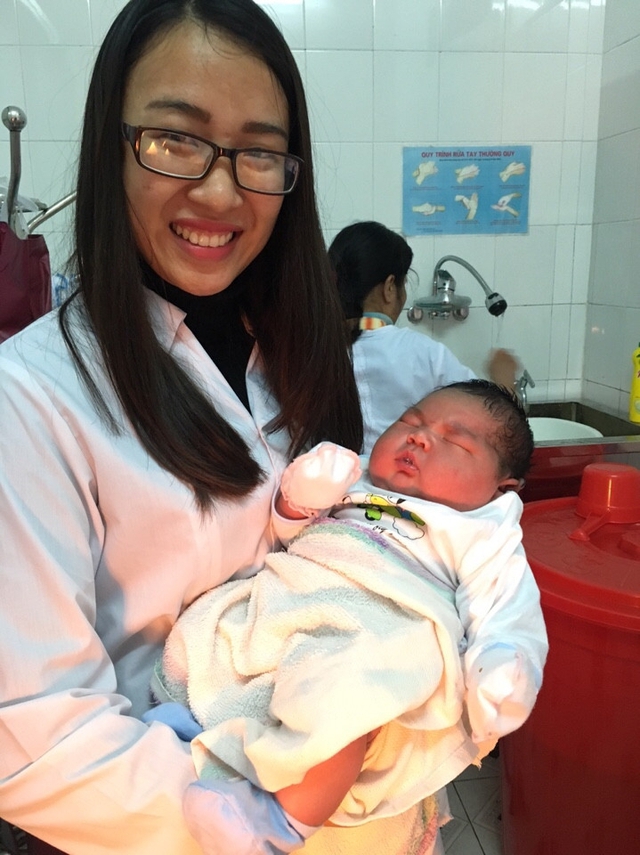 Các bác sĩ ở khoa sản Bệnh viện Đa khoa Công an tỉnh Nam Định chụp ảnh với cháu bé 6,1kg.