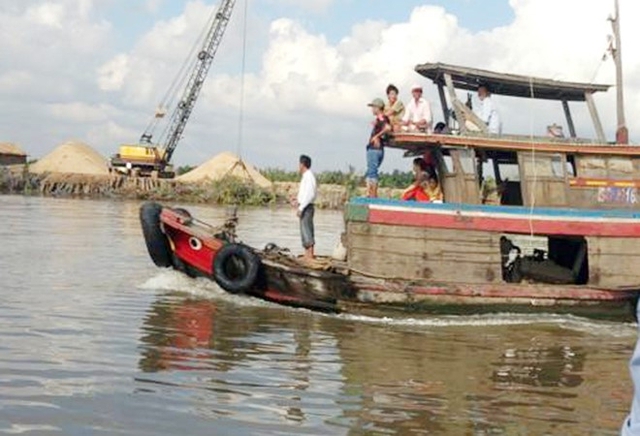 Người dân ven sông Soài Rạp hỗ trợ công an phương tiện và lưới để bắt cá sấu. Ảnh:Nhật Tân.