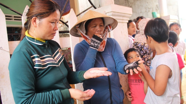 Nhiều người dân thôn Phước Thiện hoang mang kiểm tra gạo của nhà mình - Ảnh: Trần Mai