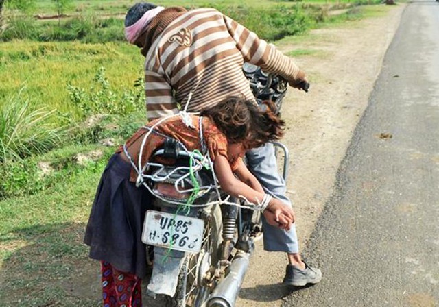 Ông bố Ấn Độ trói con vào xe chở đến trường. Ảnh: Getty Images.