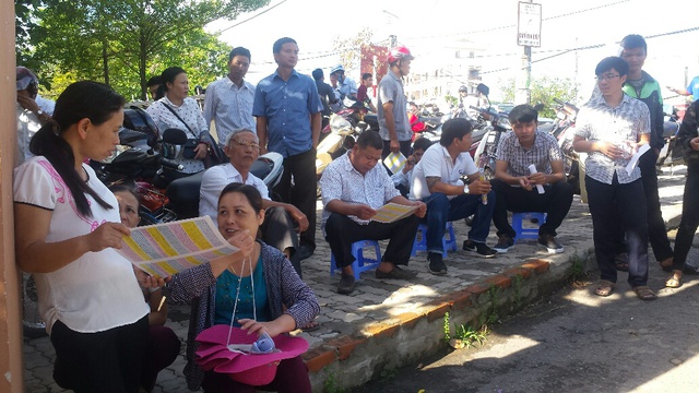 
Trong lúc đợi con vào trường làm thủ tục, phụ huynh của các sĩ tử cũng tranh thủ tìm hiểu thêm thông tin về kỳ thi THPT năm nay.. Ảnh: Lê Chung
