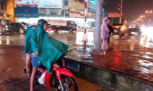 
Người đi bộ và phương tiện khó khăn di chuyển khi mưa bắt đầu nặng hat. Ảnh: Đ. Tuỳ
