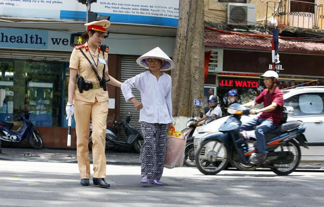 Thượng uý Phan Quỳnh Anh giúp người lớn tuổi sang đường