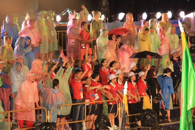 Nhiều người dân đội mưa cổ vũ cho VĐV các đoàn thể thao các nước châu Á trong lễ khai mạc...