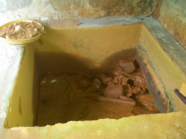 Do nguồn nước bị nhiễm phèn nặng nên bể nước của nhiều hộ dân tại thôn Lâm Xuân luôn có một màu đỏ ngàu, bùn đất đóng thành lớp dày đặc. Ảnh: C.H