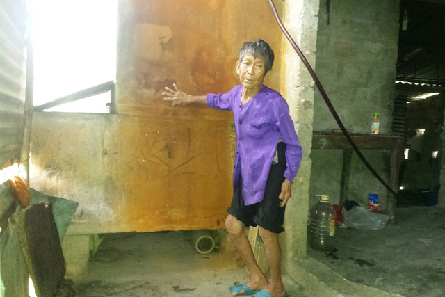 Bà Nguyễn Thị Nậy bên bể lọc đỏ ngàu của gia đình do nước bị nhiễm phèn.Ảnh: C.H