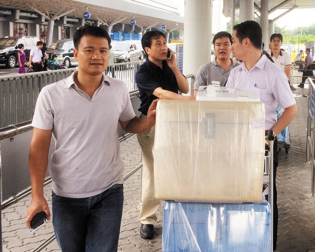 Các bác sỹ vận chuyển thùng chở tạng tại sân bay Tân Sơn Nhất. Ảnh: H.P