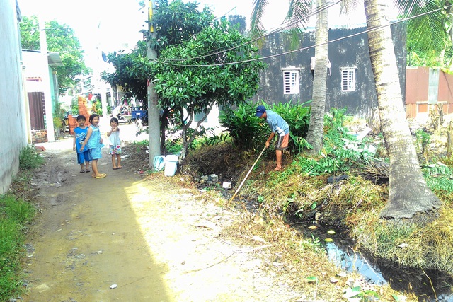 Ông Nguyễn Chí Tâm phải nghỉ kinh doanh nửa buổi để dọn dẹp, làm sạch con mương thoát nước trước nhà. Ảnh: Đỗ Bá