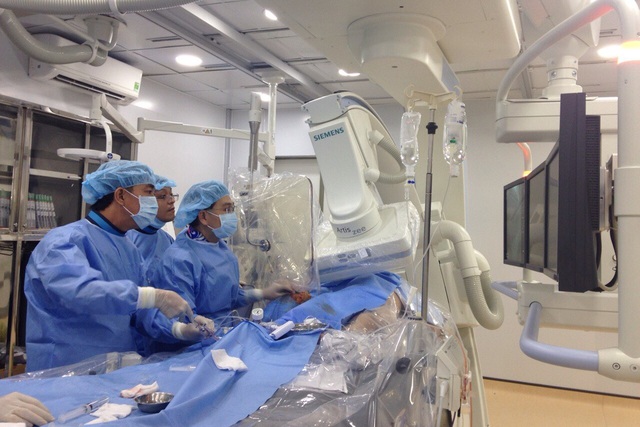BS Nguyễn Phi Vân Cương cùng ê kíp thuộc đơn vị can thiệp tim mạch Bệnh viện Quận Thủ Đức đang thực hiện ca đặt Stent đầu tiên. Ảnh: Dương Ngọc