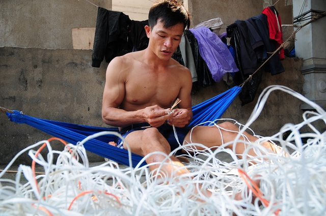 Anh Mai Xuân Lý đang ngồi đan lưới chờ ngày được trở lại biển.