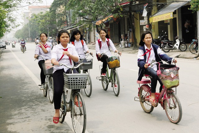 Học sinh đi xe đạp dàn hàng 3 nguy hiểm trên đường phố Hà Nội. Ảnh: Chí Cường