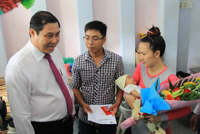 
Chủ tịch UBND TP Đà Nẵng Huỳnh Đức Thơ trao giấy khai sinh, thẻ BHYT và hộ khẩu cho gia đình anh Nguyễn Thanh Phong. Ảnh: Đ.H
