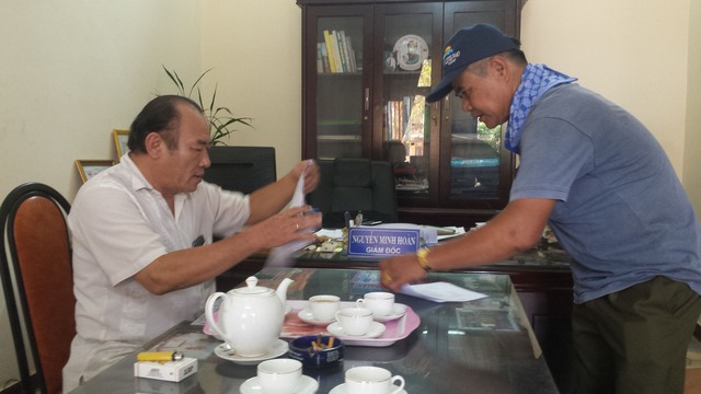Ông Nguyễn Minh Hoàn, Giám đốc Nhà khách 27-7 xác nhận các thủ tục, chế độ cho thân nhân các liệt sĩ. Ảnh: L.Chung