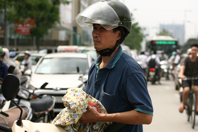 Một phụ huynh chuẩn bị sẵn đồ tránh nắng cho con.