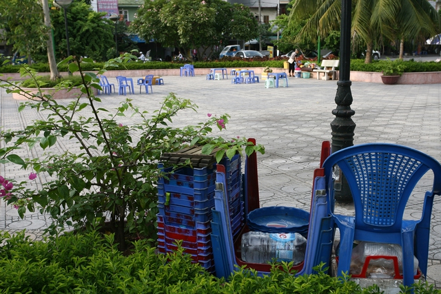 Chuẩn bị bày bàn ghế để kinh doanh tại vườn hoa Yên Hòa.