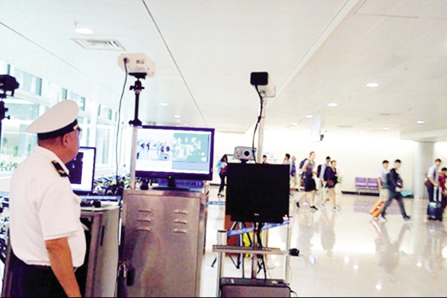 Đo thân nhiệt cho hành khách tại sân bay quốc tế Tân Sơn Nhất bằng máy đo thân nhiệt từ xa. Ảnh: Hiếu Hiền