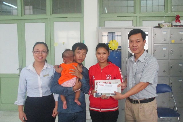 Ông Nguyễn Ngọc Đức, Phó Tổng Biên tập Báo (bên phải) cùng cán bộ công tác xã hội Bệnh viện Việt Đức trao tiền bạn đọc hảo tâm giúp đỡ gia đình cháu Duy. Ảnh: Tất Thắng