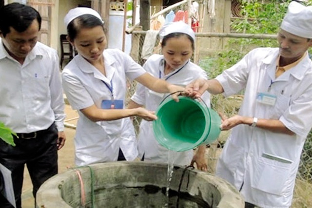 Cán bộ y tế hướng dẫn người dân xử lý nước sinh hoạt trong mùa mưa lũ. Ảnh: V.Vũ