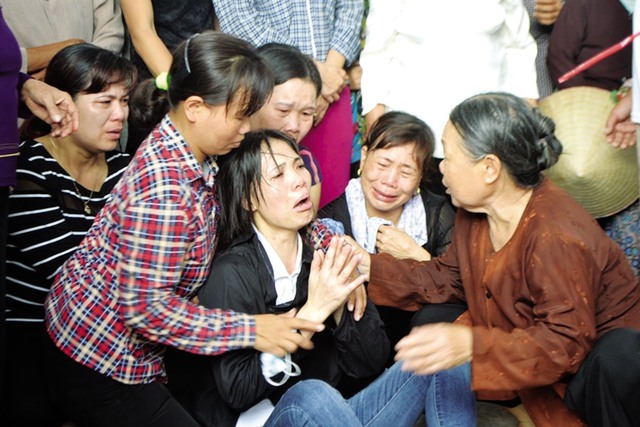 Chị Thanh và người thân khóc ngất bên di quan của những nạn nhân xấu số. Ảnh: Đ.Tùy