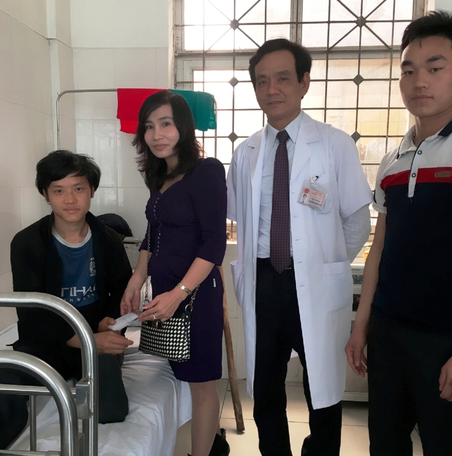 Viện trưởng Nguyễn Quang Trung cùng nhà từ thiện tới thăm anh Lùng tại giường bệnh. Ảnh: THủy Hạnh