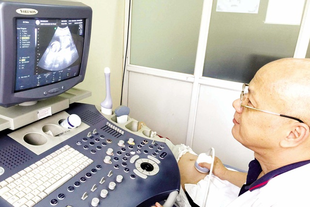 BS Nguyễn Anh Tuấn đang thăm khám, siêu âm cho một thai phụ. Ảnh: Q.An