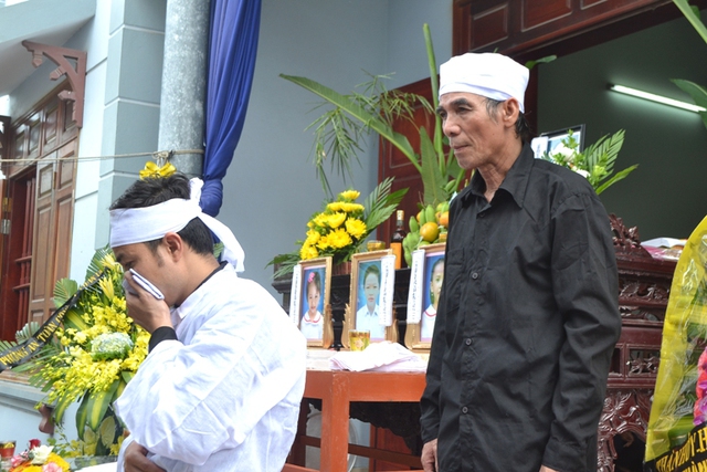 
Hai bố con ông Vũ Văn Hùng lặng người bên di ảnh người thân trước giờ làm lễ
