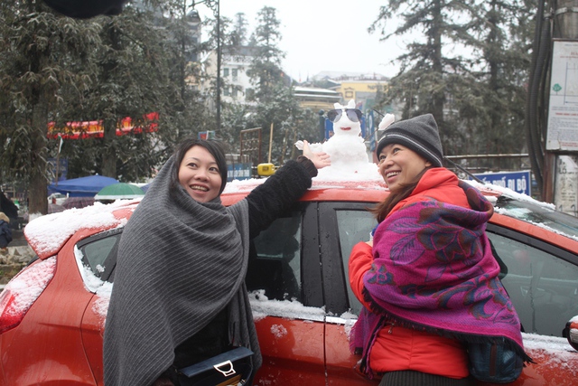 Bất chấp mưa tuyết lạnh giá, du khách cũng không bỏ lỡ cơ hội chụp ảnh bên những bông tuyết trắng xóa.