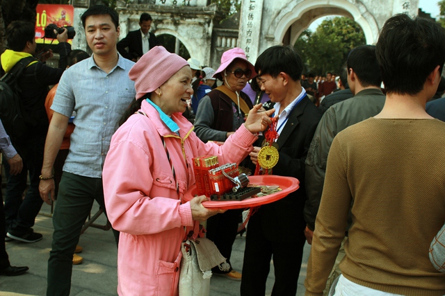 Bên ngoài các cổng đền, nhiều người bán hàng rong chèo kéo khách mua hàng.