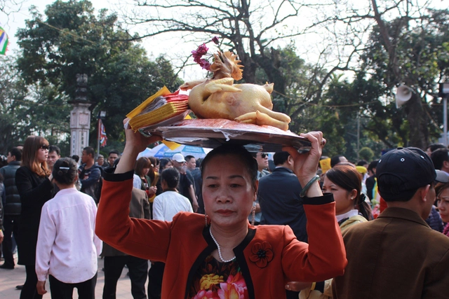 
Rất đông du khách thập phương đền lễ với những mâm lễ trên vai, túi nhỏ túi to đựng lễ vật, tiến.
