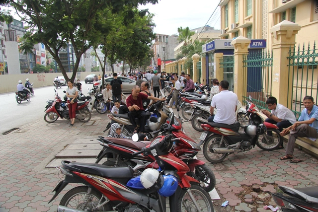 
Phụ huynh đứng, ngồi kín các quán nước, gốc cây trước cổng trường, dường như ai cũng lo lắng hướng ánh mắt về phía trường, nơi con em họ đang làm bài thi.
