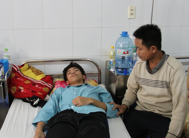 
Ông Nguyễn Tin ngồi chăm sóc em Trường ở Bệnh viện Đa khoa Đà Nẵng. Ảnh: Đức Hoàng
