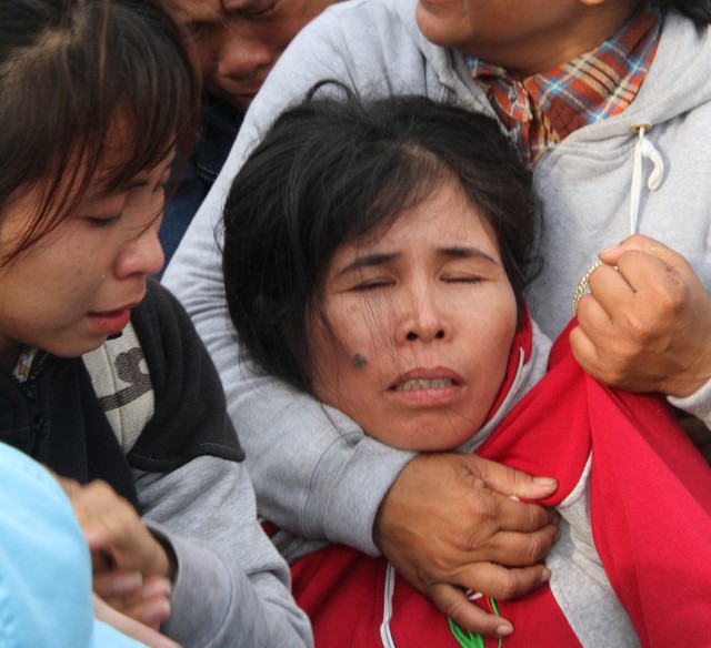 Một người phụ nữ khóc ngất ngay tại bến cảng khi thấy người thân trở về. Ảnh: Đức Hoàng