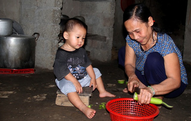 
Bà Khuyên vừa trông cháu vừa tranh thủ chuẩn bị bữa tối
