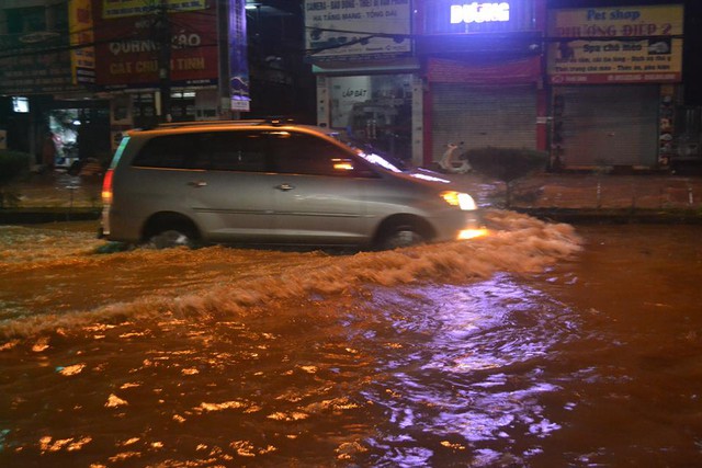 
Nước ngập trong các tuyến đường trung tâm thành phố gây khó khăn cho người đi lại. Ảnh: Đức Tùy
