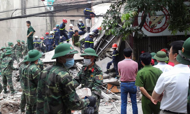 Lực lượng chức năng đang cấp tập giải cứu nạn nhân cuối cùng (Nguyễn Thị Hằng) từ đống đổ nát. Ảnh: Quang Thành