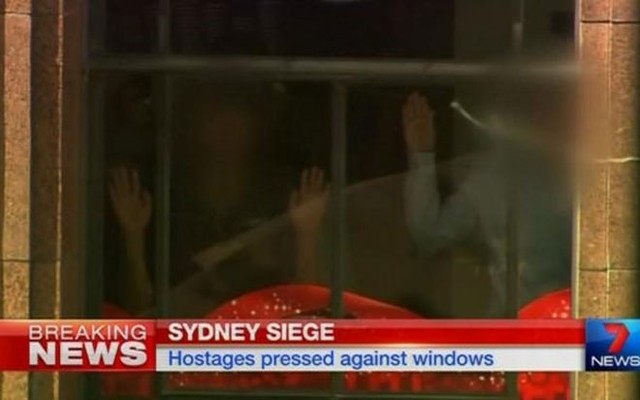Các con tin bị những kẻ bắt cóc buộc úp mặt vào cửa sổ, hai tay giơ cao. Cảnh sát bang New South Wales cho biết chưa liên lạc được với kẻ bắt cóc - Ảnh: Reuters.</p></div><div></div></div><p> </p><p>