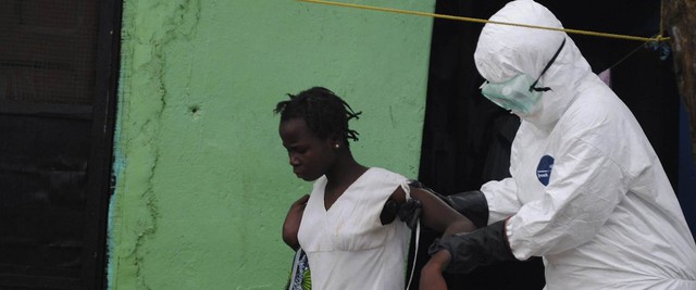 Image: Health worker brings a woman suspected of having contracted the Ebola virus to an ambulance in Monrovia