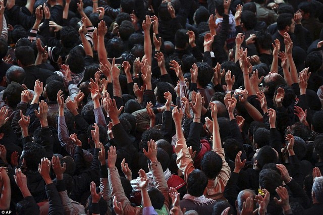 Những người sùng đạo giơ tay ca ngợi Imam Hussein.