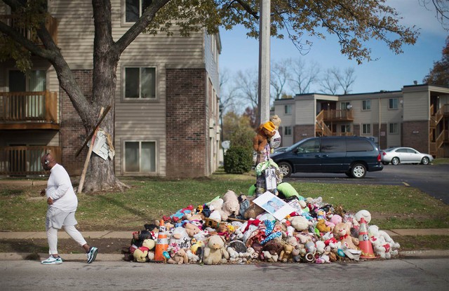 Một người chạy bộ qua đài tưởng niệm tại địa điểm mà Michael Brown đã bị bắn chết bởi cảnh sát Ferguson Darren Wilson, ở Ferguson, Missouri hôm 5/11. Bạo loạn đã nổ ra trong thành phố sau cái chết của Brown. Một bồi thẩm đoàn đang điều tra và sẽ xác định truy tố Wilson.