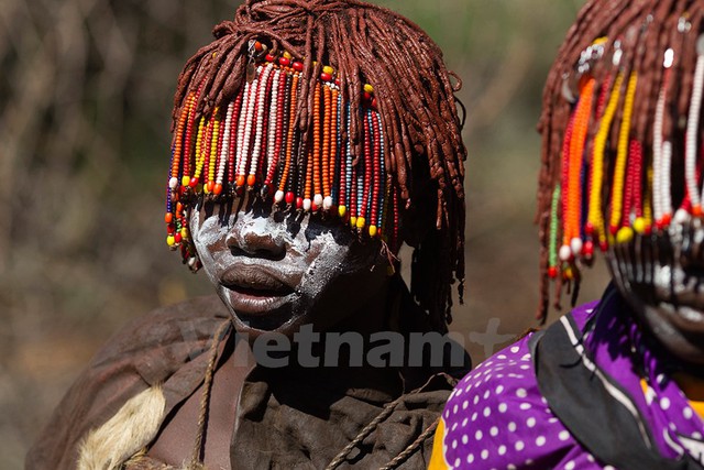 Các bé gái Pokot đeo chuỗi hạt và vẽ mặt đi về phía căn lều, tự tách biệt mình với cộng đồng nam giới. Ảnh: Siegfried Modola/Reuters