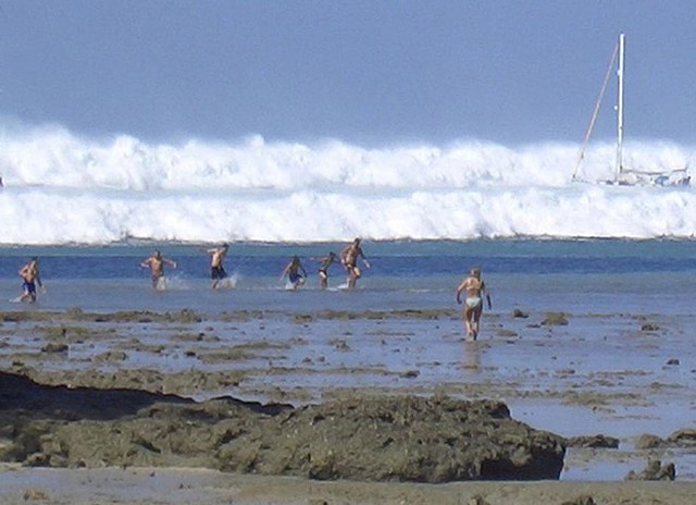 Ảnh chụp ngày 26/12/2004. Khi đó, những du khách nước ngoài đang bơi tại bãi biển Hat Rai Lay, gần Krabi, ở miền nam Thái Lan hốt hoảng chạy vào bờ khi trông thấy những ngọn sóng cao cuồn cuộn. Ảnh: AFP