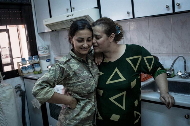 Phút gần gũi của hai mẹ con nữ binh Jin (trái) tại căn bếp của nhà họ ở Girke Lege, Syria. Mặc dù sống ở khu căn cứ gần nhà nhưng do những quy định của YPJ nên một tháng qua, cô mới được gặp mẹ.