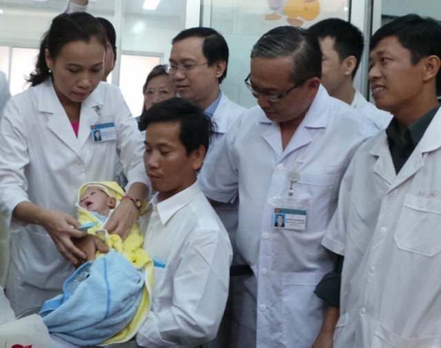 BS Thanh Tâm (trái) và BS Thanh Hùng (phải) dặn dò, động viên anh Nam bố của bé Huy tại lễ tiễn hai bố con xuất viện về quê sáng nay.