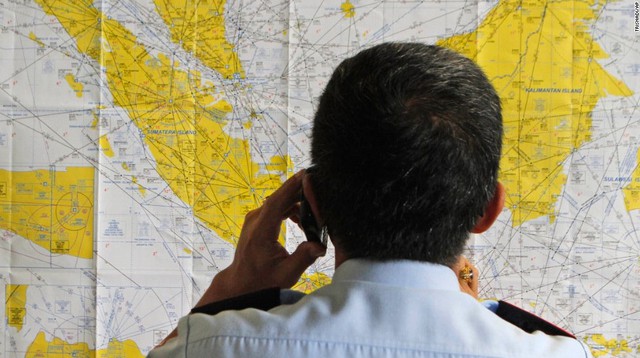 Một quan chức sân bay kiểm tra bản đồ của Indonesia tại Trung tâm xử lý khủng hoảng máy bay mất tích QZ8501, được thành lập bởi chính quyền địa phương tại sân bay quốc tế Juanda.